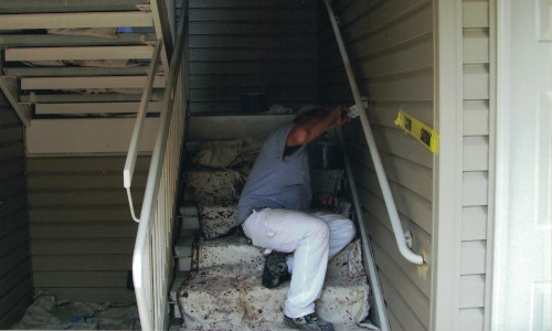 Photo of carefully painting the handrail of some stairs.