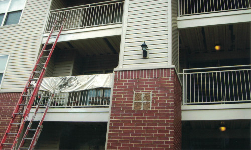 Photo of multiple ladders going up to multiple apartment decks.